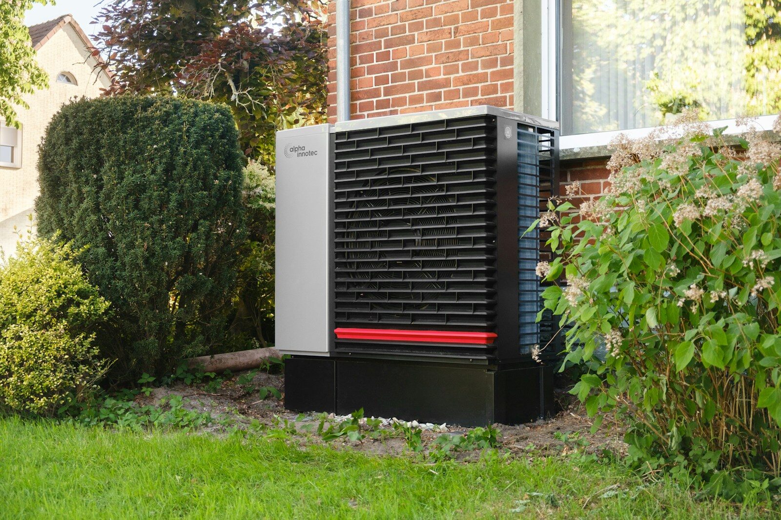 Outdoor heat pump unit next to a brick building.